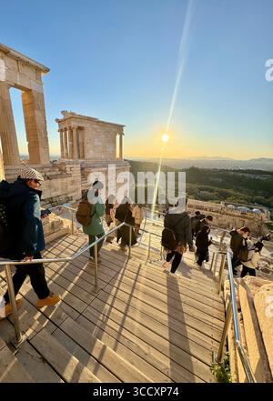 Coucher de soleil heure d'or à l'entrée du complexe de l'Acropole (Acrópole Propileia) à Athènes, Grèce, avec des touristes marchant dans les escaliers. Banque D'Images