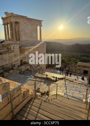 Coucher de soleil heure d'or à l'entrée du complexe de l'Acropole (Acrópole Propileia) à Athènes, Grèce, avec des touristes marchant dans les escaliers. Banque D'Images