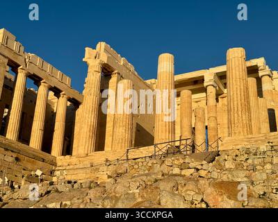 Coucher de soleil heure d'or à l'entrée du complexe de l'Acropole (Acrópole Propileia) à Athènes, Grèce, avec des touristes marchant dans les escaliers. Banque D'Images