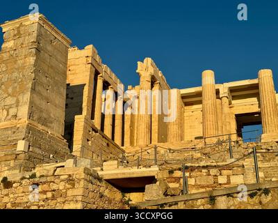 Coucher de soleil heure d'or à l'entrée du complexe de l'Acropole (Acrópole Propileia) à Athènes, Grèce, avec des touristes marchant dans les escaliers. Banque D'Images