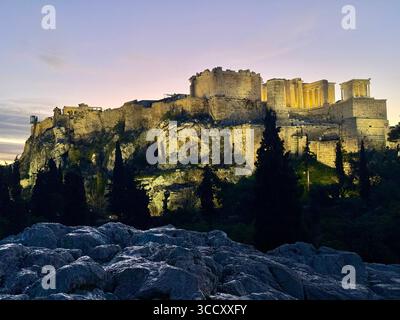 Lever de soleil sur la colline d'Areopagus avec la lumière chaude du matin illuminant l'Acropole et le paysage urbain d'Athènes. Banque D'Images
