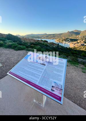 Vue panoramique depuis le site archéologique du Cap Sounion avec le temple de Poséidon en arrière-plan, et signalisation éducative pour les visiteurs. Banque D'Images