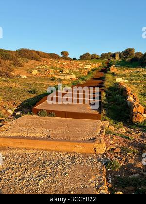 La lumière de l'heure d'or baigne le site archéologique de Sounion, en Grèce, y compris les sentiers et les ruines près du temple de Poséidon. Banque D'Images