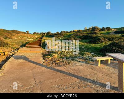 La lumière de l'heure d'or baigne le site archéologique de Sounion, en Grèce, y compris les sentiers et les ruines près du temple de Poséidon. Banque D'Images