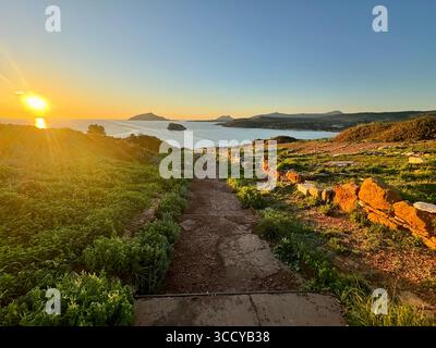 La lumière de l'heure d'or baigne le site archéologique de Sounion, en Grèce, y compris les sentiers et les ruines près du temple de Poséidon. Banque D'Images