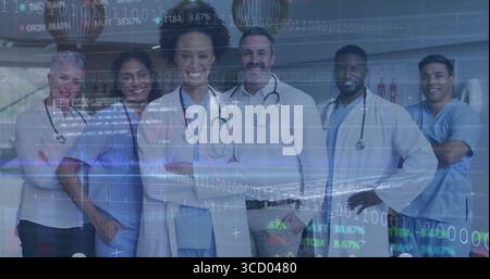 Équipe debout portant des blouses de laboratoire, des gommages bleus, des stéthoscopes dans le couloir de l'hôpital, avec superposition des données Banque D'Images