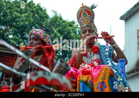 Narayanganj, Bangladesh - 23 août 2019 : vue de deux jeunes individus, ornés de costumes vibrants et de couvre-chefs ornés, jouent de la flûte au milieu d'un esprit Banque D'Images