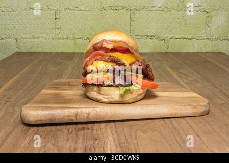 Authentique Pub Food : double hamburger avec œuf frit et frites coupées épaisses, servi dans un panier en métal enveloppé de papier Banque D'Images
