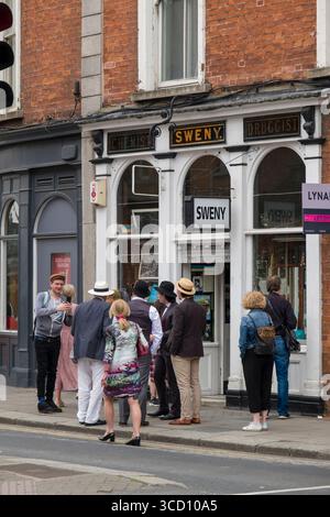 Groupe de personnes portant des vêtements d'époque des années 1920 debout devant l'historique Sweny's Pharmacy pendant la célébration du Bloomsday, Lincoln place, Dublin, I. Banque D'Images