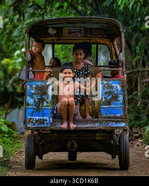 Bogura, Bangladesh - 23 août 2018 : vue d'enfants voyageant joyeusement dans un auto-pousse, leurs rires faisant écho à travers le paysage verdoyant. Banque D'Images