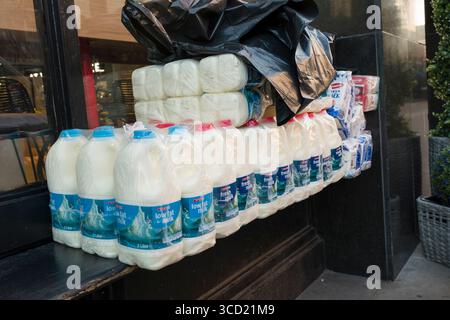 Contenants de 2 litres de lait frais emballés en plastique sur le banc à l'extérieur de l'épicerie SPAR Gourmet, Lower Baggot Street, Southside, Dublin, Irlande Banque D'Images