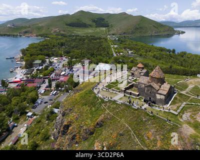 Vue aérienne d'un monastère animé sur une colline entourée d'un lac, de montagnes et d'un petit village, vue aérienne, monastère Sevanavank, monastère Sevan, GEG Banque D'Images