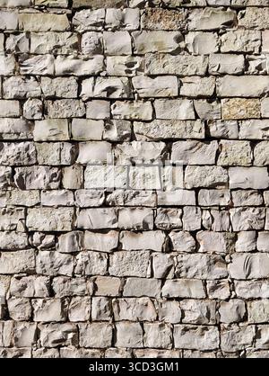 Fond vertical d'un vieux mur de pierre légère. Banque D'Images