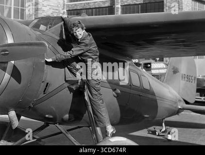 AMELIA EARHART (1897-1937) pionnière de l'aviation américaine avec son Lockheed 5C Vega rouge droit en 1932. Banque D'Images