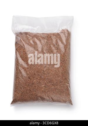 Vue de dessus des graines de lin dans un sac en plastique isolé sur blanc Banque D'Images
