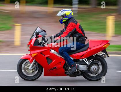 Milton Keynes,Bucks,UK - 3 août 2025 : moto Honda vfr 800 rouge 1999 voyageant sur une route britannique Banque D'Images