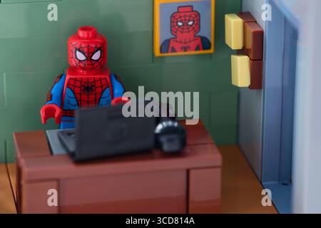 Tambov, Fédération de Russie - 12 février 2025 figurine Lego Spider-Man travaillant derrière un ordinateur portable noir sur le lieu de travail au bureau Banque D'Images