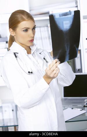 Female doctor examining x-ray photo et s'inquiète Banque D'Images