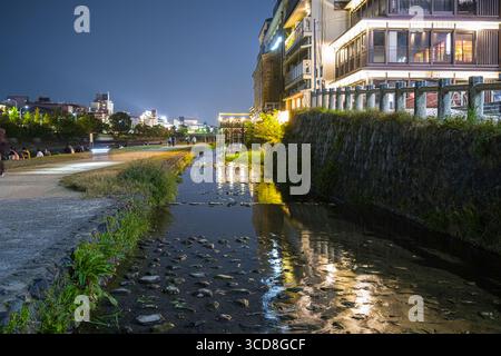 Canal peu profond coulant sur le côté ouest de la rivière Kamogawa la nuit, quartier Nakagyo, Kyoto, Kansai, Honshu, Japon Banque D'Images