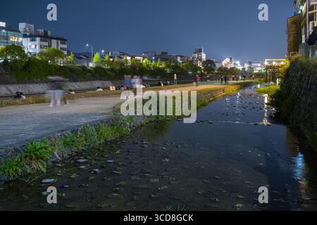 Canal peu profond coulant sur le côté ouest de la rivière Kamogawa la nuit, quartier Nakagyo, Kyoto, Kansai, Honshu, Japon Banque D'Images
