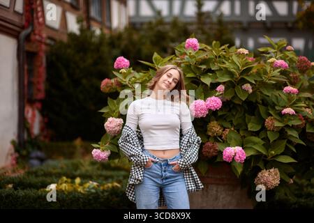 Capturez l'essence de la mode automnale et du charme de la campagne allemande avec ce portrait captivant en plein air. Une jeune femme, habillée dans un casu tendance Banque D'Images
