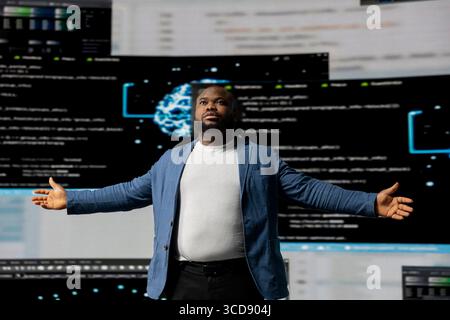 Spécialiste du programmeur noir s'engageant dans le développement de logiciels sur un poste de travail de haute technologie, concentré sur son écran. Présentation de la vie de codage, de l'algorithme INFORMATIQUE, du cloud computing dans le monde de la technologie. Banque D'Images