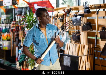 Portrait d'homme afro-américain choisissant Pitchfork sur le marché Banque D'Images
