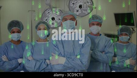 Équipe chirurgicale debout portant des blouses bleues et des masques dans la salle d'opération, avec lumières moniteur de statif IV Banque D'Images