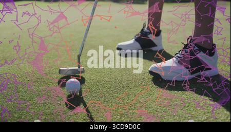 Golfeur alignant la tête de putter avec la balle de golf sur vert, chaussettes de cheville, chaussures de golf, avec recouvrement numérique Banque D'Images