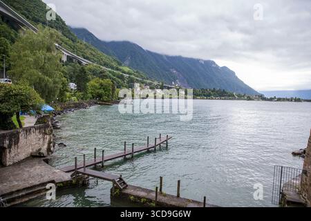 Vue aérienne par drone du lac Léman entouré par les montagnes des Alpes suisses, paysage pittoresque, eau bleue, vallées verdoyantes et villes pittoresques. Banque D'Images