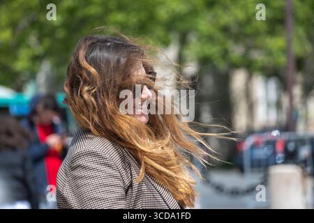 Paris, France, 16 mai 2023. Portrait de jeune touriste souriant au soleil et profitant de la ville. Concept de vacances et de voyage. Banque D'Images