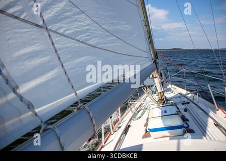 Yacht à voile de luxe sous gênes et grand voile coupant à travers les vagues de la mer Baltique, golfe de Finlande. Vue du pont à la proue, mât et voiles, emphas Banque D'Images