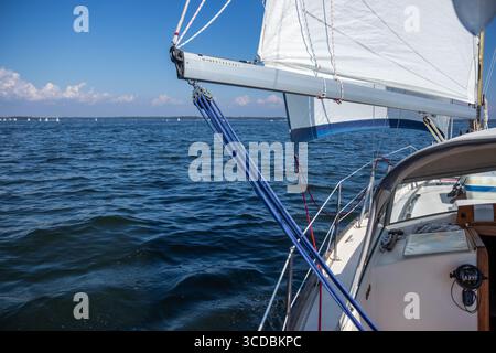 Yacht à voile de luxe sous gênes et grand voile coupant à travers les vagues de la mer Baltique, golfe de Finlande. Vue du pont à la proue, mât et voiles, emphas Banque D'Images