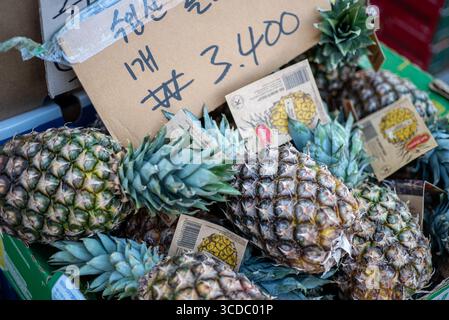 Un tas d'ananas frais mis en vente sur un marché, avec une étiquette de prix montrant 3 400 won coréens à Séoul, Corée du Sud, le 20 mars 2024 Banque D'Images