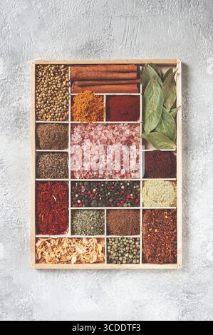 Un assortiment d'épices disposées sur un plateau en bois, disposées dans des compartiments en bois, vue de dessus Banque D'Images