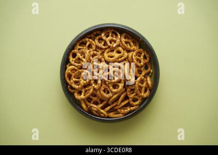 Vue de dessus d'un bol avec des bretzels salés isolés sur fond d'olive Banque D'Images