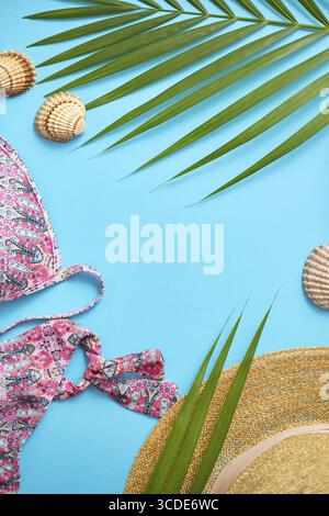 Vêtements d'été de plage de femmes et accessoires collage sur fond bleu. Avec bikini, chapeau, sac de plage, feuille de palmier. Pose à plat. Vue de dessus Banque D'Images