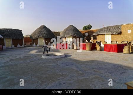 Village de tentes touristiques dans le désert du Thar, près de Jaisalmer, Rajasthan, Inde du Nord, cabanes de boue traditionnelles avec des toits de chaume sous un ciel bleu, Jaisalmer Banque D'Images