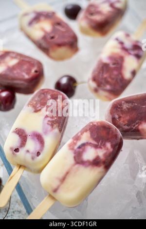 Délicieux Popsicles végétaliens faits maison aux cerises avec lait de coco. Concept d'alimentation saine d'été. Vue de dessus, pose à plat Banque D'Images