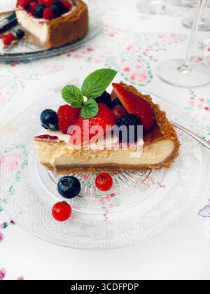 Cheesecake New-yorkais aux baies décorées de menthe fraîche, sur une table. Desserts faits maison. Banque D'Images