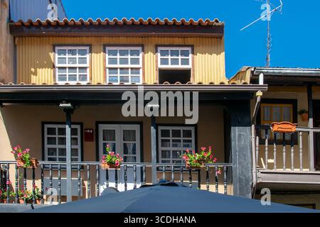 Une vue de niveau bas d'un charmant bâtiment avec un grand parasol noir sur sa terrasse, un café ou un restaurant en plein air dans la ville de chaves, portugal Banque D'Images