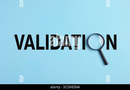 Mot de validation écrit en lettres noires sur fond bleu avec une loupe l'analysant Banque D'Images