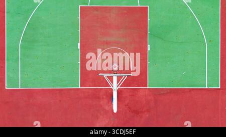 Vue aérienne d'un terrain de basket-ball extérieur et d'un cerceau montrant la surface de jeu rouge et verte Banque D'Images
