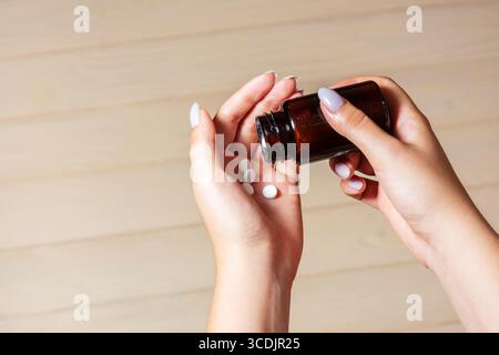Verser des pilules blanches de Amber Medicine Bottle Banque D'Images