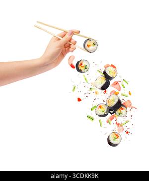 Morceaux de sushi tombant et rouleau de sushi avec des baguettes en bois dans la main féminine, isolé sur fond blanc Banque D'Images
