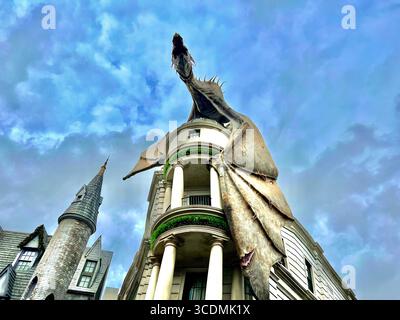 Dragon crachant le feu perché au sommet de Gringotts Bank sous le ciel nuageux dans le monde des sorciers de Harry Potter à Universal Studios à Orlando, en Floride. Banque D'Images