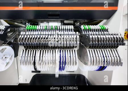 L'invention concerne des dispositifs d'alimentation de bande sur une machine de saisie et de placement à technologie de montage en surface pendant le fonctionnement dans une usine de fabrication Banque D'Images