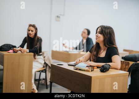 Des élèves du secondaire engagés écoutent attentivement pendant une leçon en classe Banque D'Images