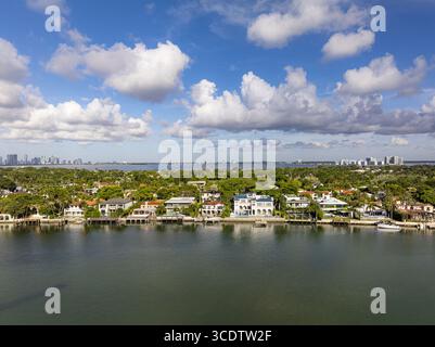 Vue aérienne des somptueuses maisons de front de mer bordant la paisible voie navigable intracoastale, encadrée par la verdure luxuriante de l'île de la Gorce avec le SK de la ville de Miami Banque D'Images
