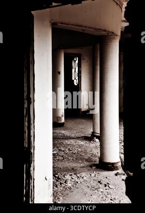 Une photo intérieure d'un bâtiment abandonné, avec des colonnes et une porte. Banque D'Images